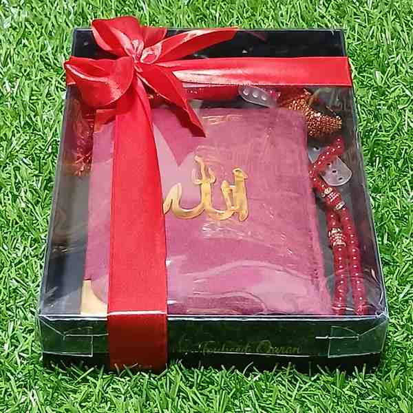 Gift set with a Black box, rosary, and red ribbon on grass
